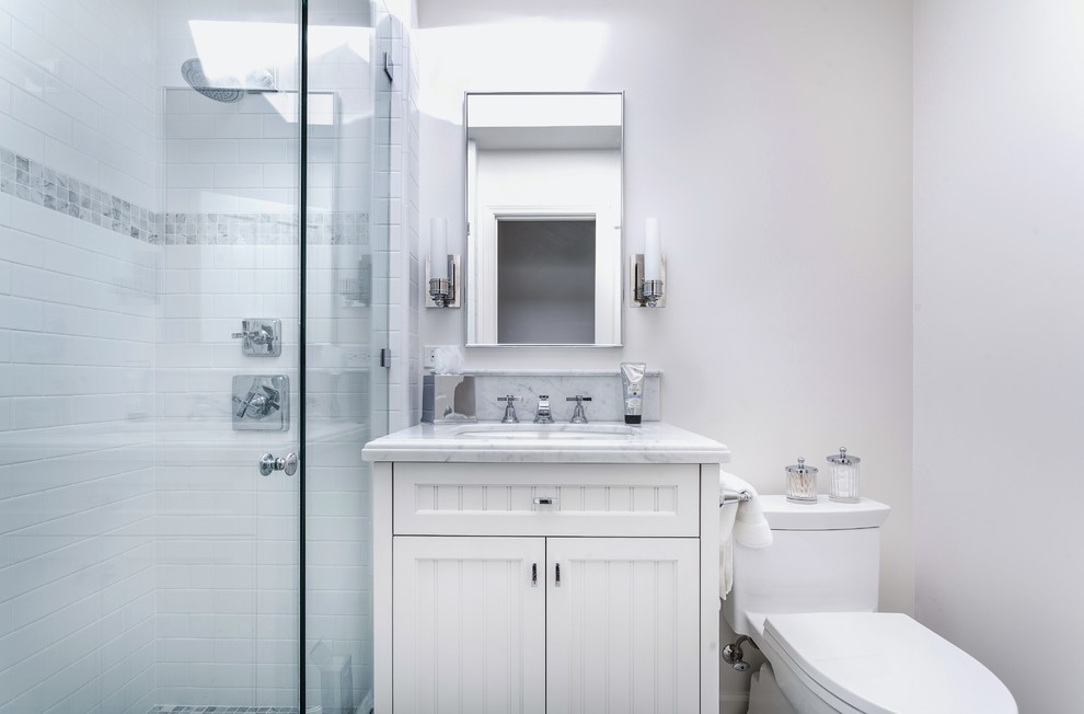 Small beach style 3/4 bathroom in Santa Barbara with an undermount sink, beaded inset cabinets, white cabinets, marble benchtops, a one-piece toilet, white tile, stone tile, white walls and mosaic tile floors.