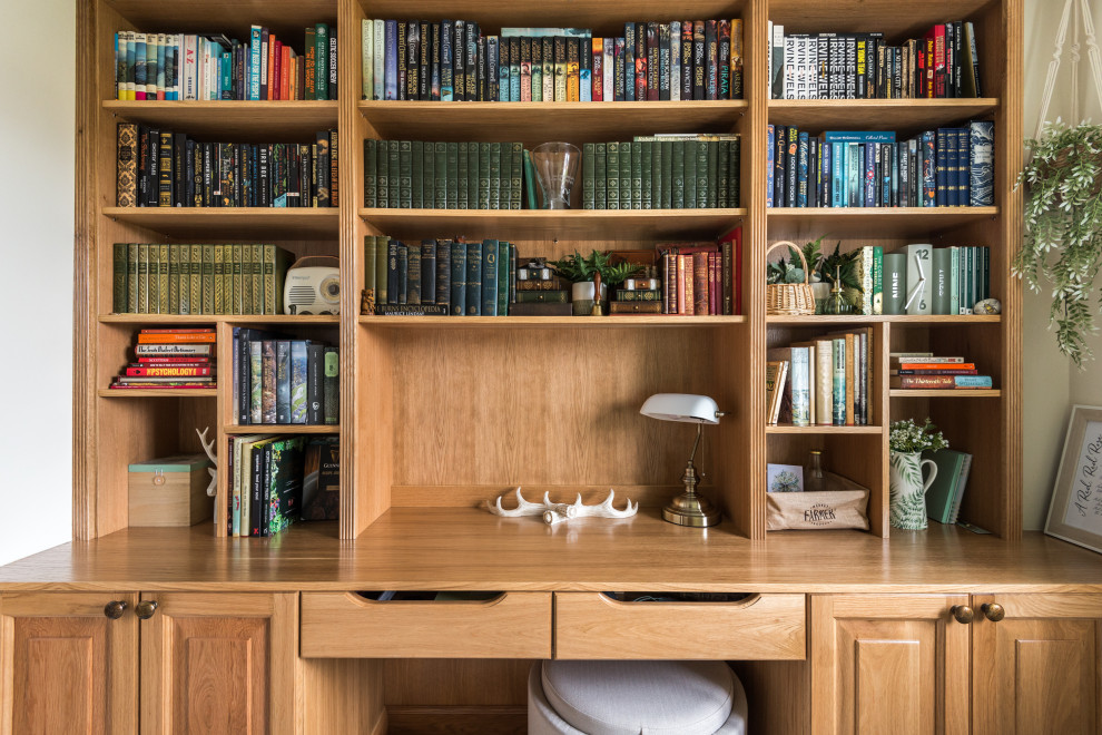 На фото: домашняя библиотека среднего размера в классическом стиле с белыми стенами, ковровым покрытием, встроенным рабочим столом и серым полом