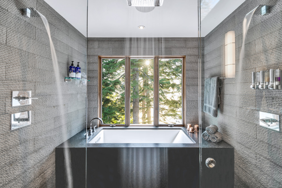 Large country master bathroom in Other with brown cabinets, an undermount tub, a shower/bathtub combo, a one-piece toilet, gray tile, stone tile, grey walls, ceramic floors, a vessel sink, granite benchtops, grey floor, a sliding shower screen and grey benchtops.