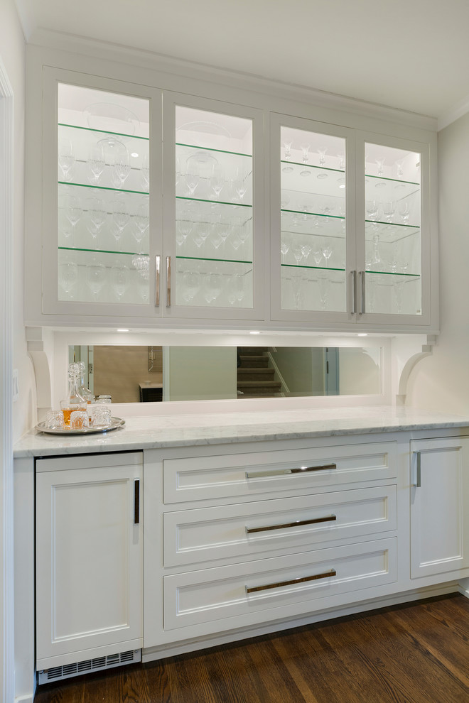 This is an example of a mid-sized traditional single-wall wet bar in Minneapolis with shaker cabinets, white cabinets, marble benchtops and dark hardwood floors.