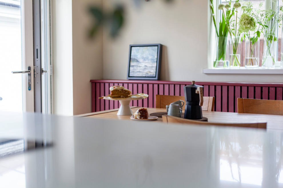 Inspiration för en mellanstor minimalistisk matplats med öppen planlösning, med vita väggar, kalkstensgolv, en öppen vedspis och beiget golv