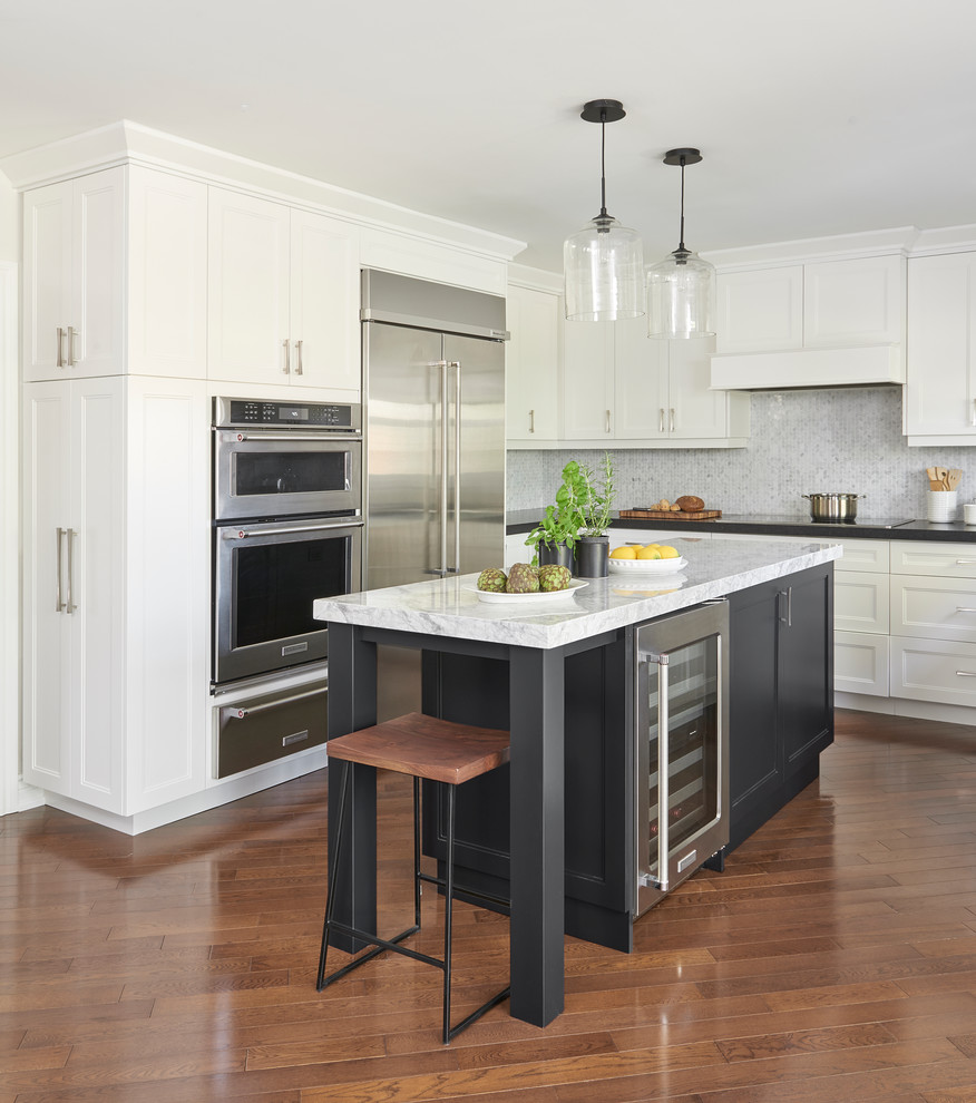 This is an example of a transitional l-shaped eat-in kitchen in Toronto with shaker cabinets, white cabinets, marble benchtops, white splashback, marble splashback, stainless steel appliances, medium hardwood floors and with island.