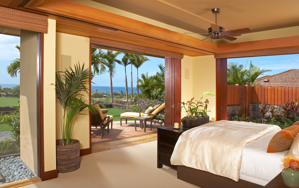 Tropical master bedroom in Hawaii with beige walls and no fireplace.