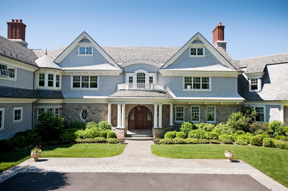 This is an example of a large traditional three-storey blue house exterior in New York with wood siding, a gambrel roof and a shingle roof.