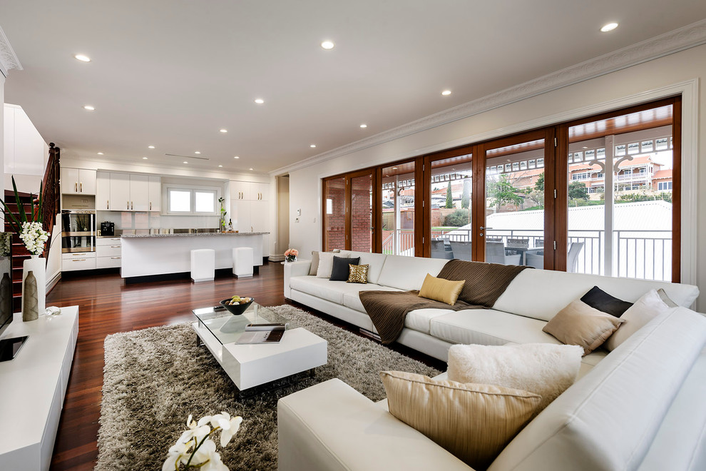 This is an example of a contemporary open concept living room in Perth with beige walls.
