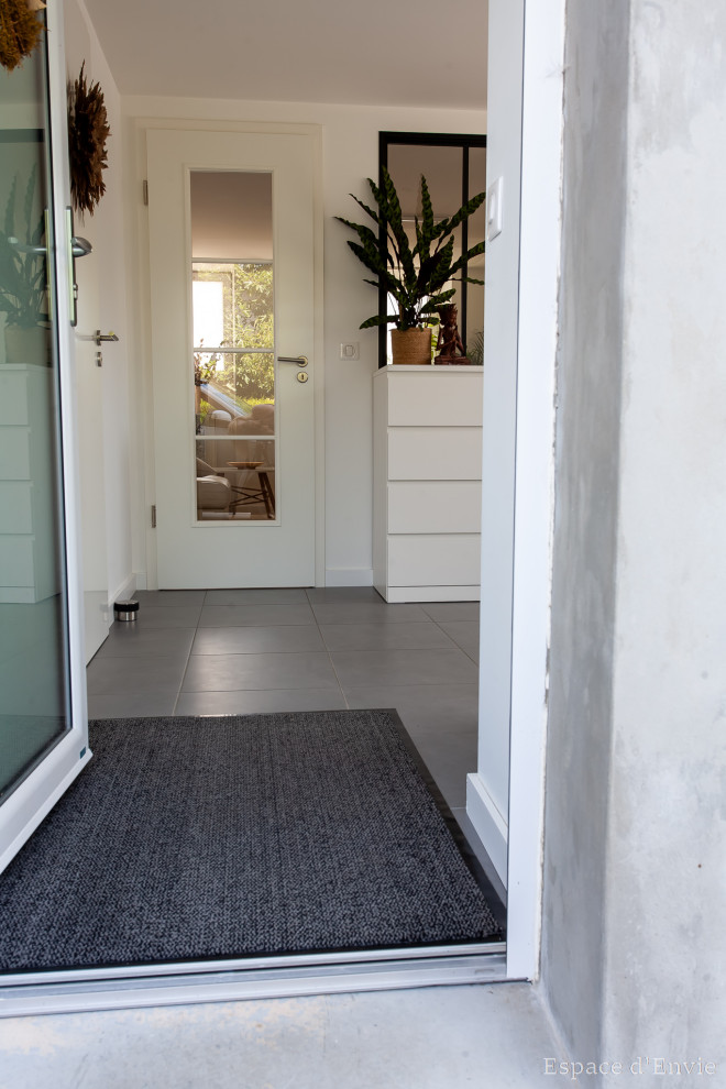 Свежая идея для дизайна: фойе среднего размера в скандинавском стиле с белыми стенами, полом из керамической плитки, одностворчатой входной дверью, белой входной дверью и серым полом - отличное фото интерьера