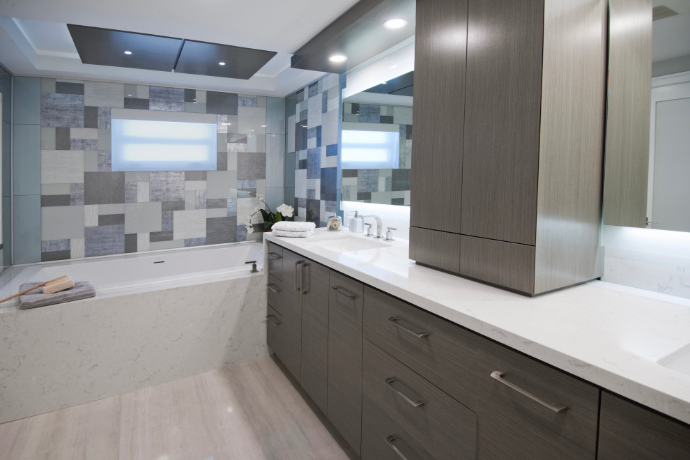 This is an example of a mid-sized contemporary master wet room bathroom in Miami with flat-panel cabinets, grey cabinets, a hot tub, a one-piece toilet, multi-coloured tile, glass tile, grey walls, porcelain floors, an undermount sink, engineered quartz benchtops, grey floor, a hinged shower door, grey benchtops, an enclosed toilet, a double vanity, a built-in vanity and recessed.