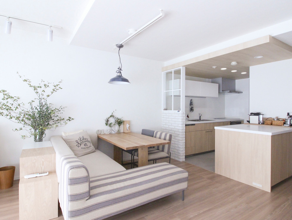 Scandinavian living room in Tokyo with white walls, light hardwood floors and brown floor.