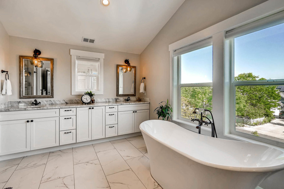 This is an example of a large country master bathroom in Denver with shaker cabinets, white cabinets, a freestanding tub, grey walls, porcelain floors, an undermount sink, engineered quartz benchtops, white floor and white benchtops.
