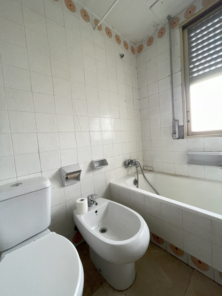 This is an example of a mid-sized midcentury master bathroom in Madrid with an alcove tub, a shower/bathtub combo, a two-piece toilet, white tile, ceramic tile, white walls, ceramic floors, a pedestal sink, beige floor, a shower curtain, a single vanity, a built-in vanity, recessed and brick walls.