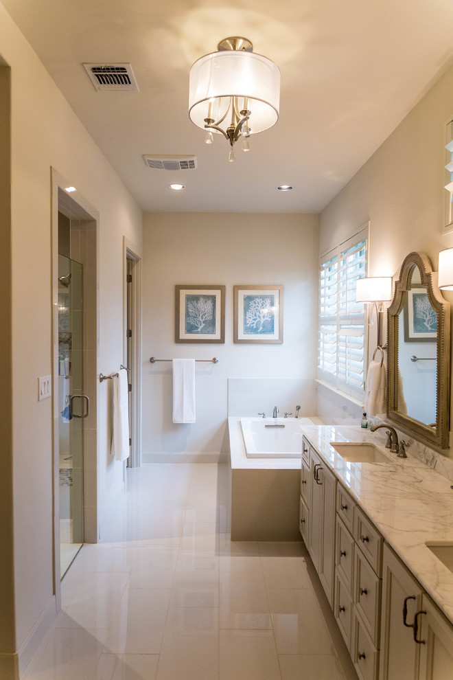 Inspiration for a large traditional master bathroom in Austin with recessed-panel cabinets, white cabinets, a corner tub, an alcove shower, white tile, porcelain tile, white walls, porcelain floors, an undermount sink and marble benchtops.