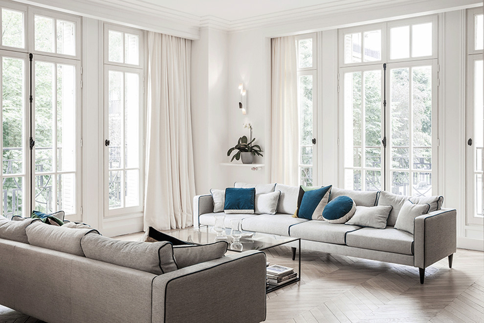 This is an example of an expansive contemporary formal open concept living room in Paris with light hardwood floors and no tv.