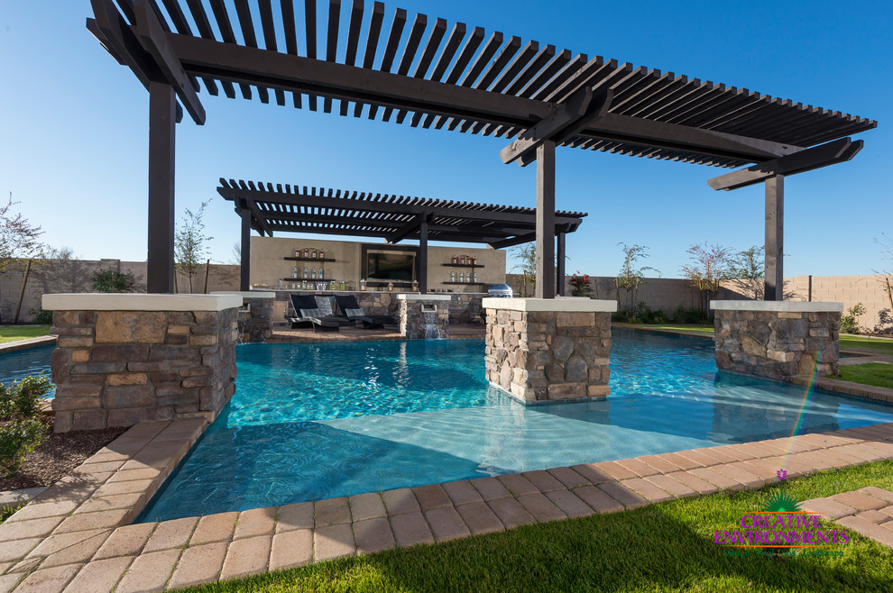 Expansive modern backyard pool in Phoenix with brick pavers.