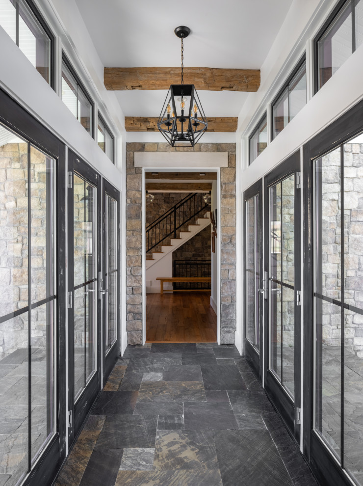 Mittelgroßes Country Foyer mit weißer Wandfarbe, Kalkstein, Doppeltür, schwarzer Haustür, grauem Boden und freigelegten Dachbalken in Kolumbus