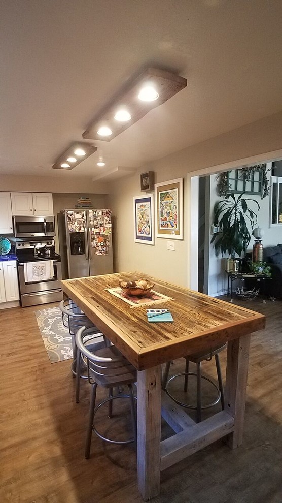 Example of a large mountain style l-shaped light wood floor and brown floor eat-in kitchen design in Denver with a double-bowl sink, raised-panel cabinets, white cabinets, stainless steel appliances, an island, tile countertops, blue backsplash and ceramic backsplash