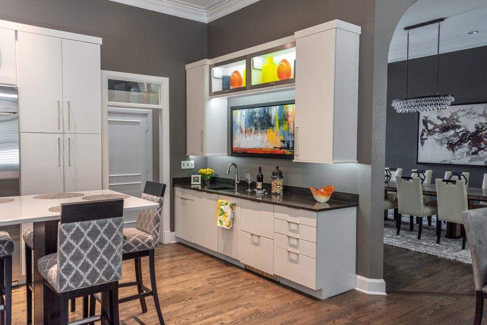 Design ideas for a large contemporary single-wall wet bar in Other with a submerged sink, flat-panel cabinets, white cabinets, engineered stone countertops, medium hardwood flooring, brown floors and black worktops.