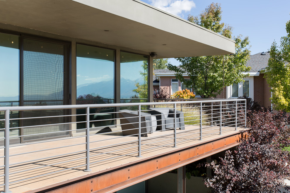 Mid-sized mid-century modern front porch photo in Salt Lake City with a roof extension