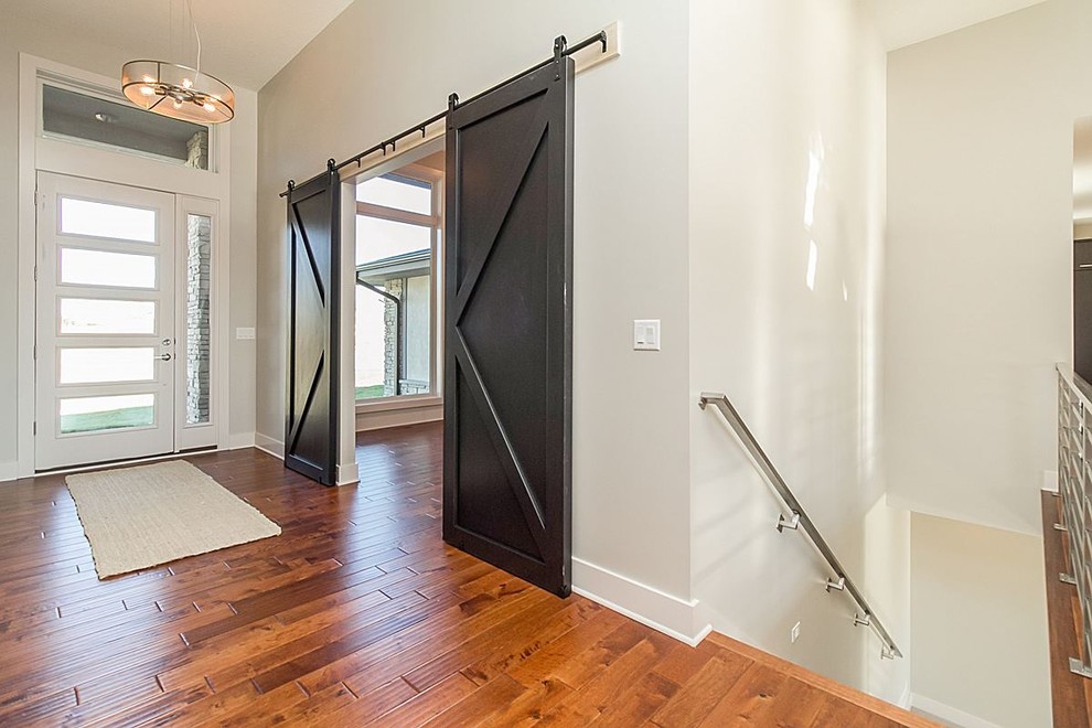 Foyer - large transitional medium tone wood floor and brown floor foyer idea with gray walls and a white front door