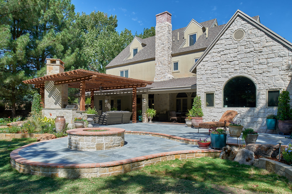 Inspiration for a traditional backyard garden in Austin with a fire feature and natural stone pavers.