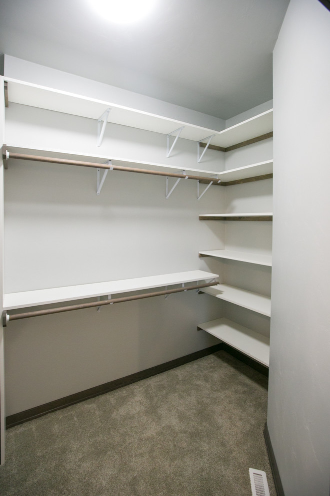 Design ideas for an expansive country gender-neutral walk-in wardrobe in Other with white cabinets and carpet.