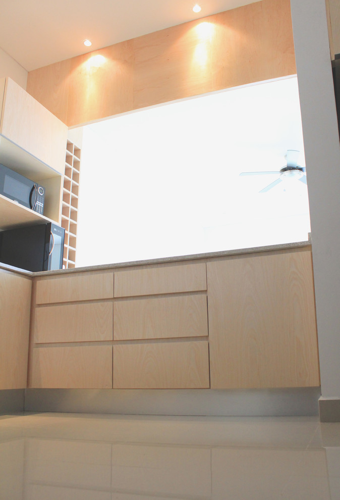 Example of a mid-sized minimalist u-shaped porcelain tile eat-in kitchen design with a double-bowl sink, flat-panel cabinets, light wood cabinets, granite countertops and stainless steel appliances