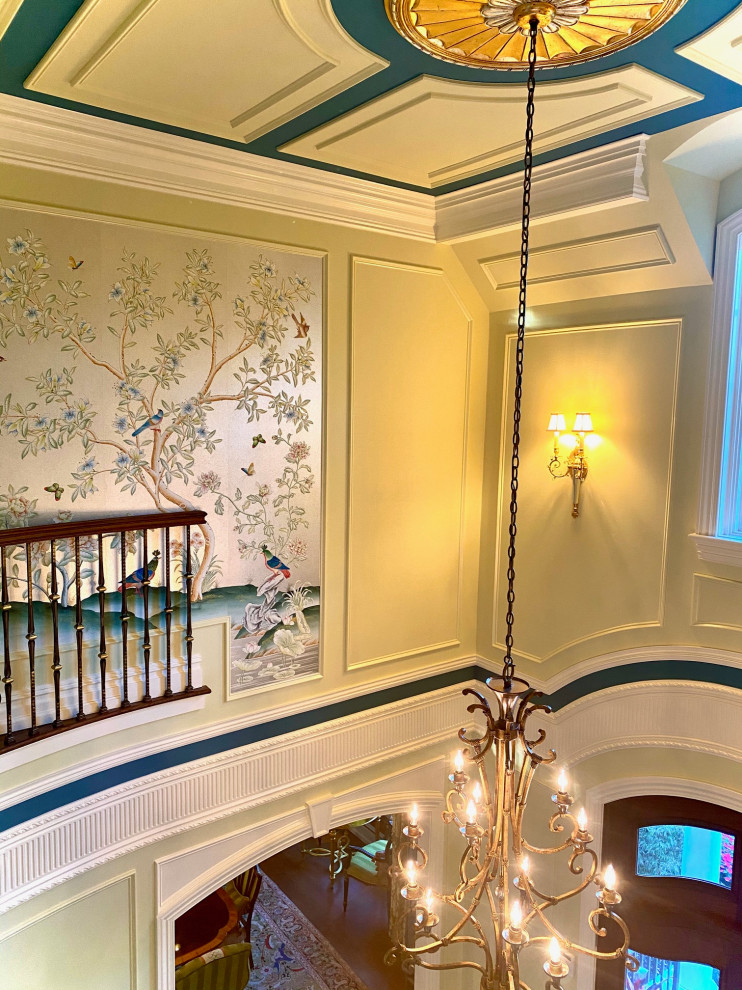 Großes Klassisches Foyer mit grüner Wandfarbe, Marmorboden, Doppeltür, brauner Haustür, weißem Boden, Kassettendecke und Wandpaneelen in New York