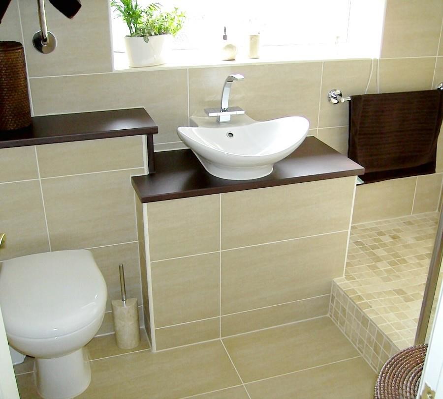 Medium sized contemporary bathroom in Essex with raised-panel cabinets, a one-piece toilet, beige tiles, porcelain tiles, porcelain flooring, a vessel sink, wooden worktops, beige floors, an open shower and brown worktops.