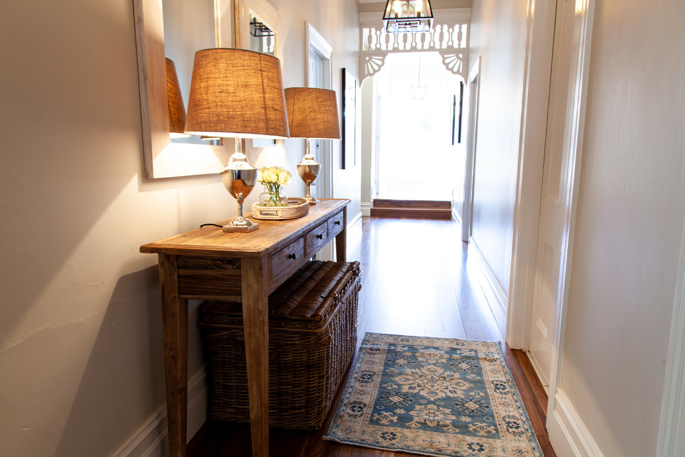 Small country foyer in Melbourne with grey walls, medium hardwood floors and brown floor.