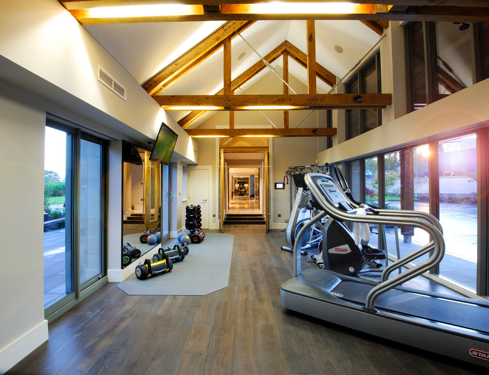 Photo of a traditional home weight room in Cheshire with beige walls and dark hardwood floors.