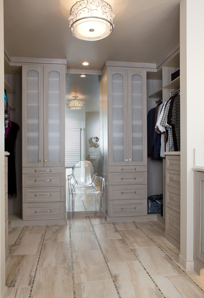 This is an example of a small modern women's walk-in wardrobe in Sacramento with recessed-panel cabinets, grey cabinets and porcelain floors.