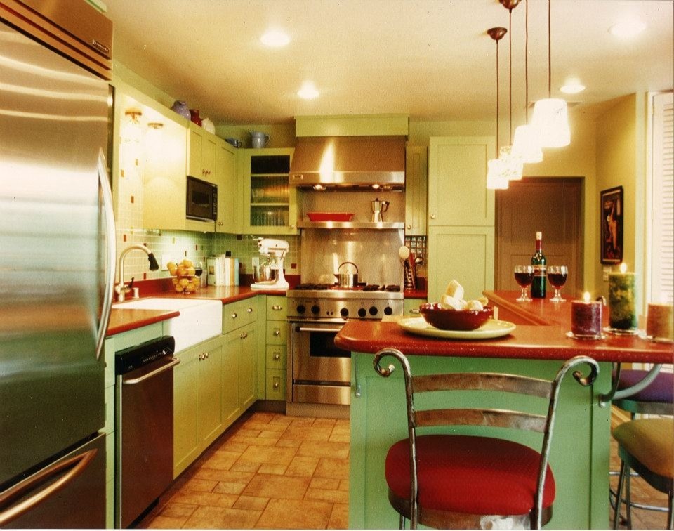 Mid-sized midcentury kitchen in Orange County with a farmhouse sink, beaded inset cabinets, multi-coloured splashback, glass tile splashback, stainless steel appliances, travertine floors, multi-coloured floor and red benchtop.