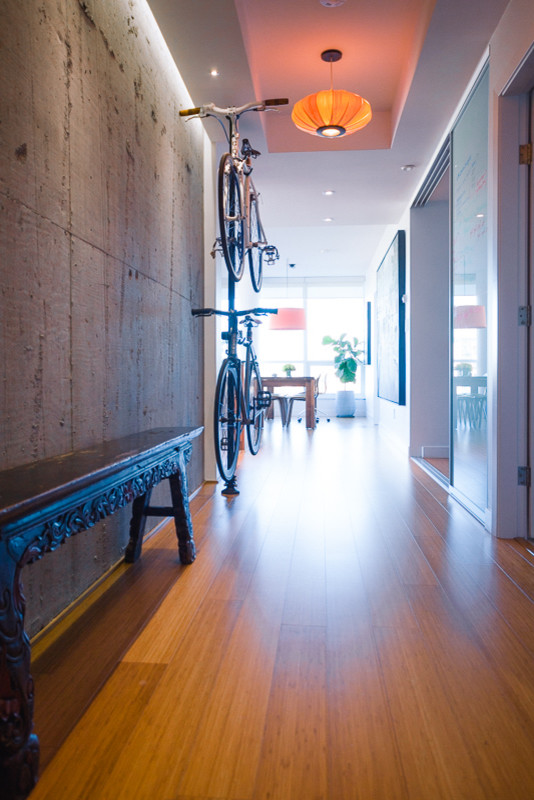 Mid-sized modern hallway in Vancouver with bamboo floors, grey walls and brown floor.