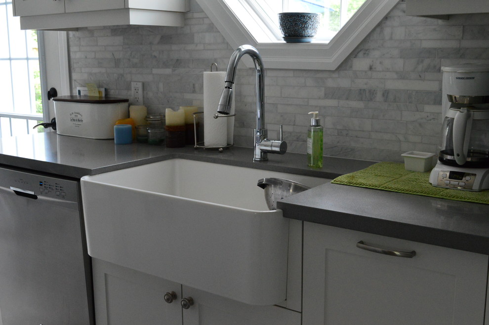 Example of a mid-sized transitional l-shaped vinyl floor and gray floor eat-in kitchen design in Toronto with a farmhouse sink, shaker cabinets, white cabinets, quartz countertops, gray backsplash, marble backsplash, stainless steel appliances and an island