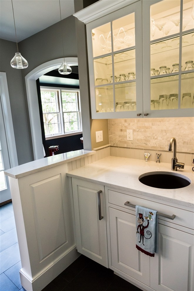 Inspiration for a mid-sized contemporary single-wall wet bar in Wichita with white cabinets, an undermount sink, raised-panel cabinets, marble benchtops, grey splashback, stone tile splashback and slate floors.