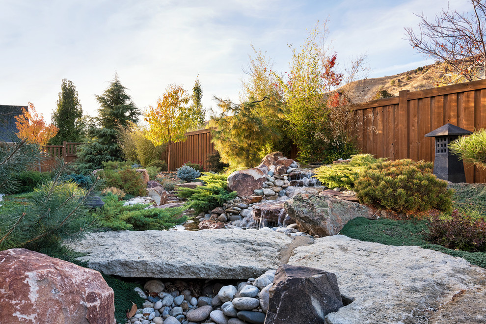 Mid-sized asian backyard partial sun formal garden in Boise with a water feature and natural stone pavers for winter.