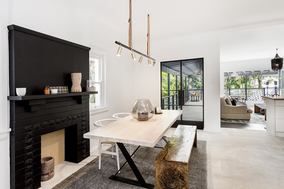 Mid-sized scandinavian kitchen/dining combo in Sydney with white walls, limestone floors and a brick fireplace surround.