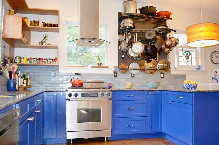 Inspiration for a mid-sized eclectic u-shaped light wood floor kitchen pantry remodel with an undermount sink, shaker cabinets, blue cabinets, granite countertops, blue backsplash, ceramic backsplash and stainless steel appliances