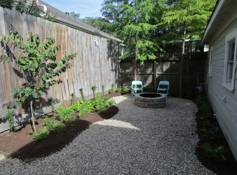 Small country backyard shaded garden in Houston with gravel.