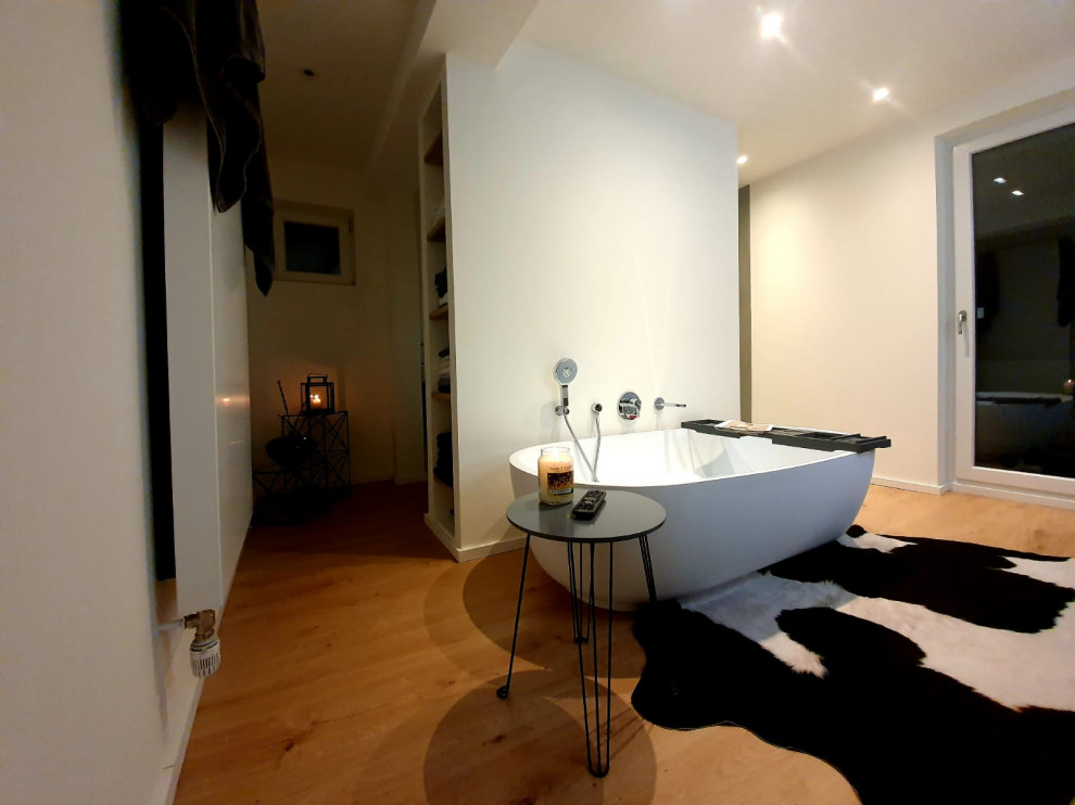 Modern inredning av ett mellanstort brun brunt badrum med dusch, med öppna hyllor, bruna skåp, ett fristående badkar, en kantlös dusch, en toalettstol med separat cisternkåpa, beige väggar, mörkt trägolv, ett fristående handfat, bänkskiva i akrylsten och med dusch som är öppen