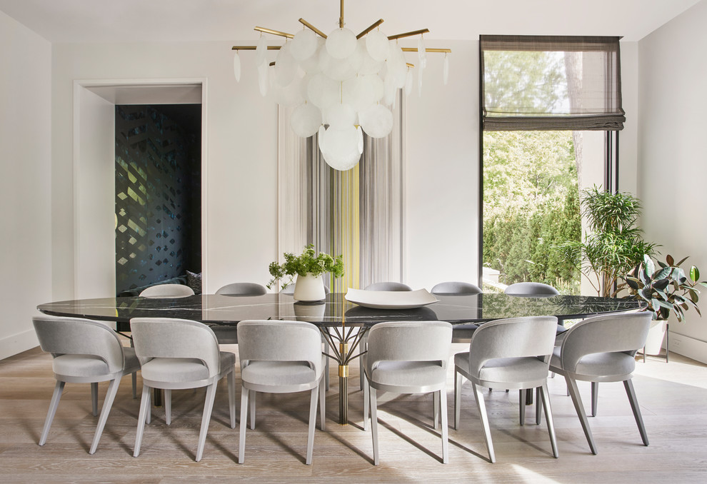 Photo of a contemporary dining room in Chicago with white walls, light hardwood floors and beige floor.