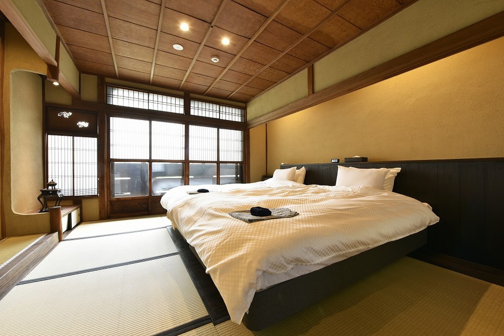 Modelo de dormitorio de estilo zen con tatami, paredes marrones y suelo verde