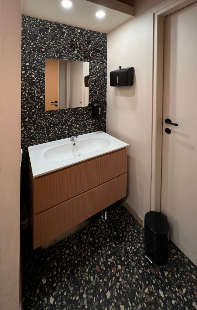 Small eclectic bathroom in Rome with raised-panel cabinets, orange cabinets, a one-piece toilet, multi-coloured tile, porcelain tile, multi-coloured walls, porcelain floors, a drop-in sink, multi-coloured floor, white benchtops, a single vanity and a floating vanity.