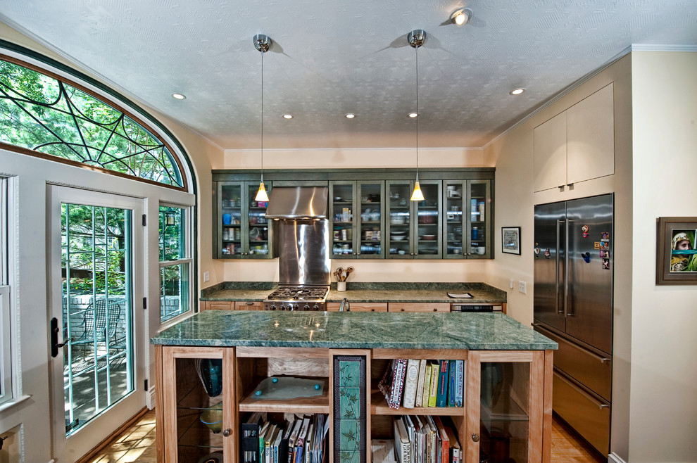 Eat-in kitchen - small transitional l-shaped medium tone wood floor eat-in kitchen idea in DC Metro with granite countertops, an island, glass-front cabinets, green cabinets, metallic backsplash, metal backsplash, stainless steel appliances and a drop-in sink