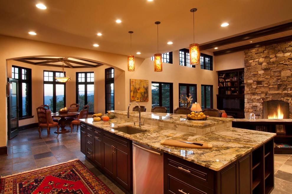 Open concept kitchen - huge transitional l-shaped slate floor open concept kitchen idea with a single-bowl sink, beaded inset cabinets, dark wood cabinets, granite countertops, beige backsplash, stone slab backsplash, stainless steel appliances, brown walls and an island
