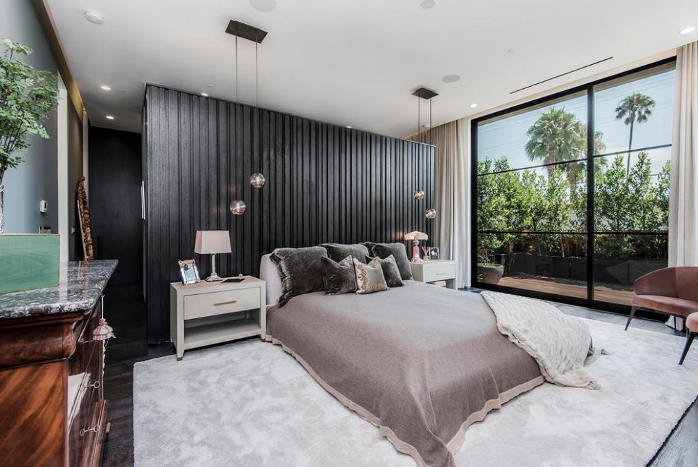 This is an example of a modern master bedroom in Los Angeles with brown floors.