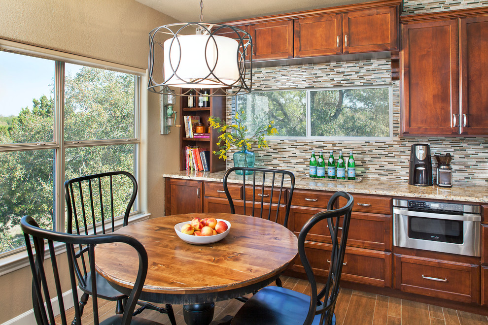 Example of a large transitional galley porcelain tile eat-in kitchen design in Austin with an undermount sink, recessed-panel cabinets, medium tone wood cabinets, granite countertops, mosaic tile backsplash, stainless steel appliances, beige walls, a peninsula and multicolored backsplash