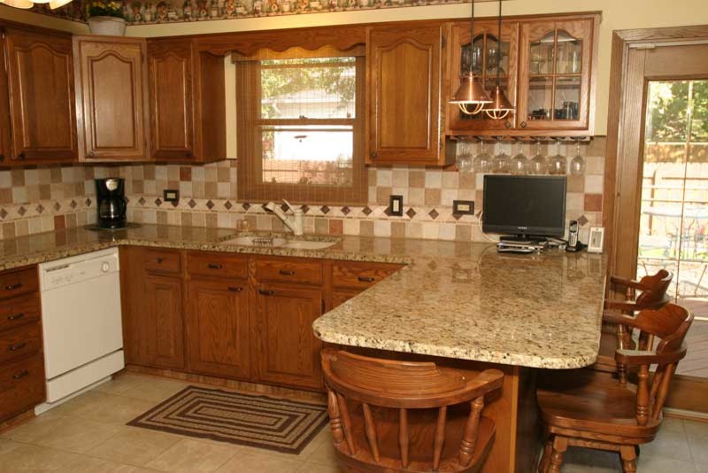 Kitchen pantry - transitional u-shaped medium tone wood floor kitchen pantry idea in Chicago with raised-panel cabinets, medium tone wood cabinets and granite countertops