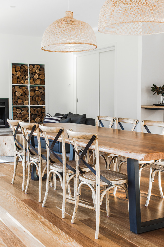 Beach style dining room in Wollongong with white walls, medium hardwood floors and brown floor.
