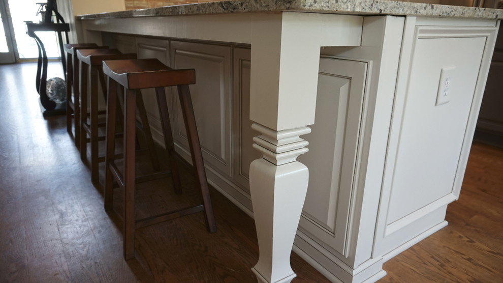 Large transitional u-shaped medium tone wood floor eat-in kitchen photo in Atlanta with an undermount sink, raised-panel cabinets, white cabinets, granite countertops, gray backsplash, ceramic backsplash, stainless steel appliances and an island