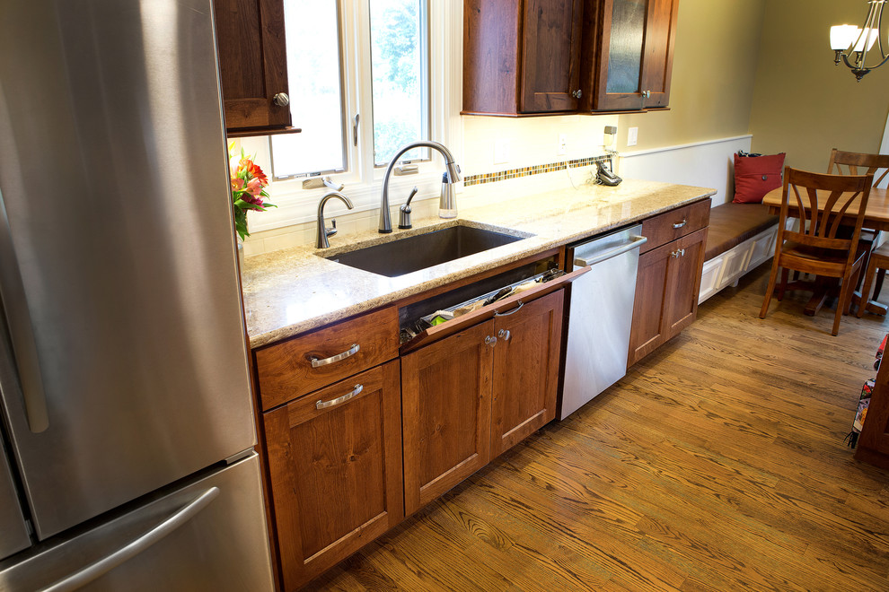 Arts and crafts eat-in kitchen in Chicago with raised-panel cabinets, medium wood cabinets and light hardwood floors.